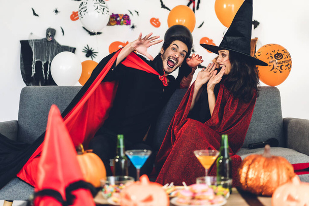 Couple having fun holding pumpkins and wearing dressed carnival  - Photo, Image