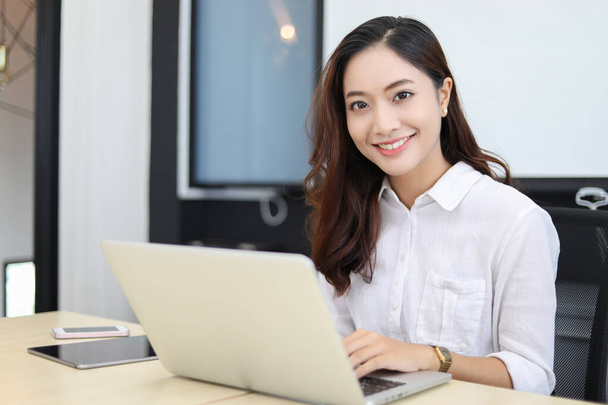 Asiático mulheres de negócios usando notebook e sorrindo feliz para worki
 - Foto, Imagem