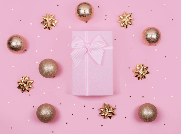 pink gift or present boxes and gold Christmas decorations on pink background top view. Flat lay. - Фото, изображение