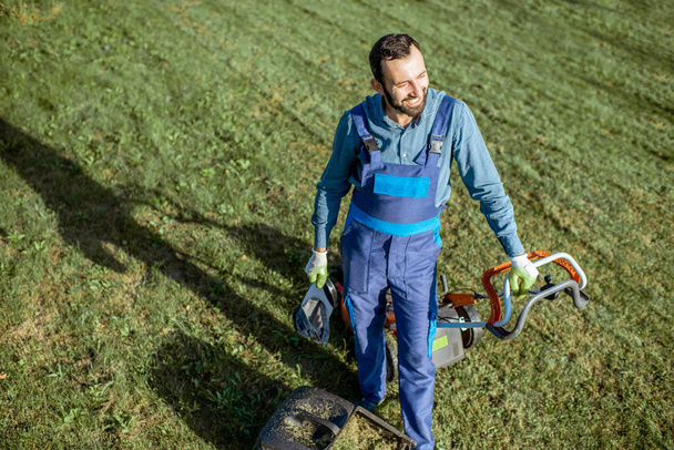 Gardener working with lawn mower on the backyard - Valokuva, kuva