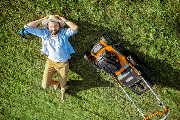 芝刈り機を持った草の上の男 - 写真・画像