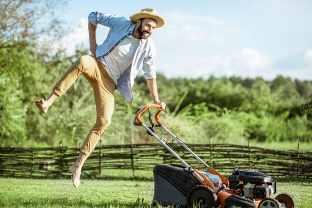 Mann mit Rasenmäher im Hinterhof - Foto, Bild