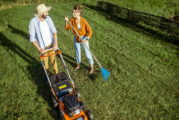 Man and woman cleaning green lawn - Valokuva, kuva