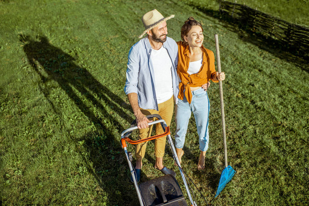 緑の芝生を掃除する男と女 - 写真・画像