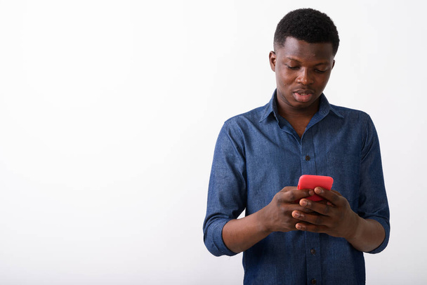 Студийный снимок молодого чернокожего африканца с помощью мобильного телефона
 - Фото, изображение