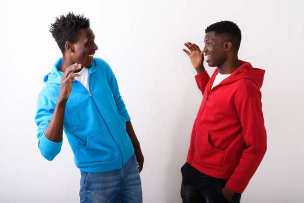 Profile view of two young happy black African friends giving hig - Фото, изображение