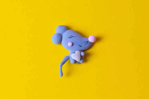 Feche o marshmallow em forma de rato ou rato cinzento com o coração isolado no fundo amarelo. Ano Novo e Natal 2020 conceito. Rato cinzento ou marshmallow de rato - símbolo do ano 2020
 - Foto, Imagem