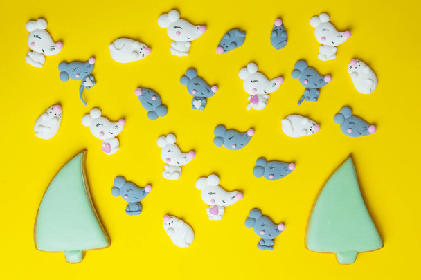 Marshmallows na forma de camundongos brancos e cinzentos ou ratos e árvores de Natal no fundo amarelo. Mini marshmallows.Top colorido vista. 2020 fundo do ano novo e textura
. - Foto, Imagem