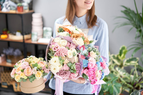 Beautiful bouquet of mixed flowers in woman hand. Floral shop concept . Handsome fresh bouquet. Flowers delivery. Red and pink color. - Photo, Image