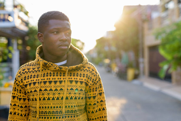 Young black African man thinking while looking to the side and w - Valokuva, kuva