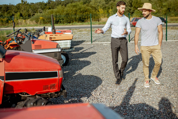 Agronomist with salesman near the tractor outdoors - Zdjęcie, obraz
