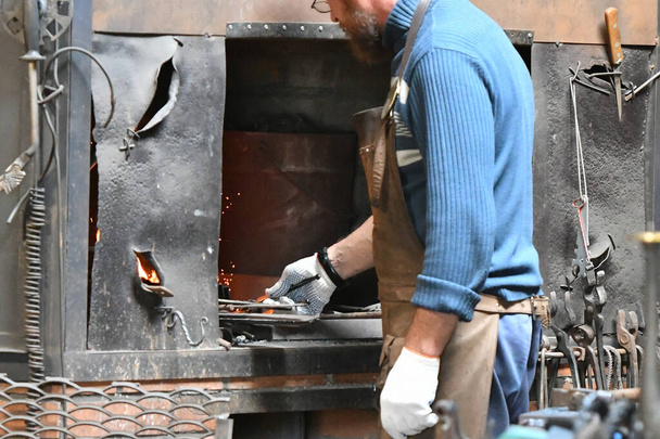 herrero trabajando. trabajar en un horno al rojo vivo
. - Foto, imagen