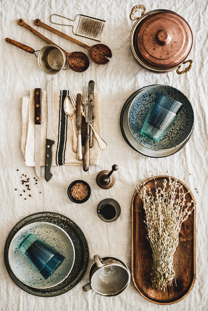 Flat-lay of various kitchen utensils, rustic tablewear, plates, dishes, glasswear, textile for cooking over white rustic linen tablecloth background, top view, vertical composition. Seasonal cooking - Foto, Imagem