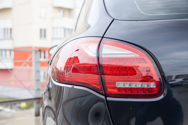 Крупним планом на задній світлодіодний гальмівний світло червоного кольору на чорному автомобілі
 - Фото, зображення