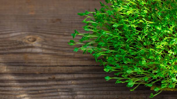 Fresh green watercress on textured old wooden background with copy space banner - Valokuva, kuva