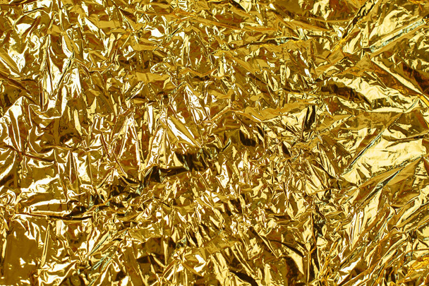 Gold leaf background texture with shiny crumpled uneven surface - Photo, Image
