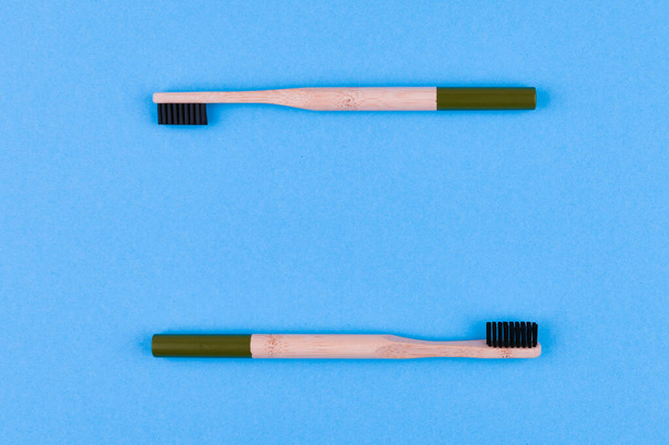 wooden toothbrush on a blue background. Close up wooden toothbrush on a blue background. eco brush. - Zdjęcie, obraz