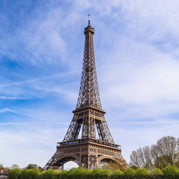 Πύργος του Άιφελ στο Παρίσι Γαλλία ενάντια στον γαλάζιο ουρανό με σύννεφα. Απριλίου - Φωτογραφία, εικόνα