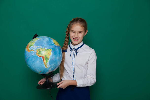 グリーンボードのクラスで地球を持つ女子高生は - 写真・画像
