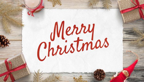 Merry Christmas greeting card surrounded by Christmas decorations and gifts. Old Vintage composition. Flat lay, top view. Wooden background. - Foto, Bild