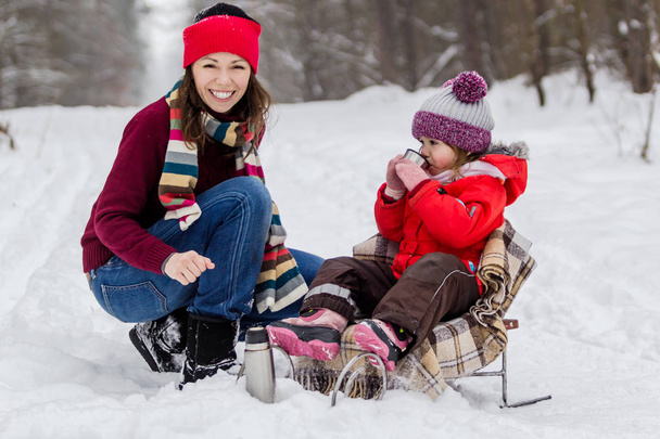 Mother and daughter having fun at winter time. - 写真・画像
