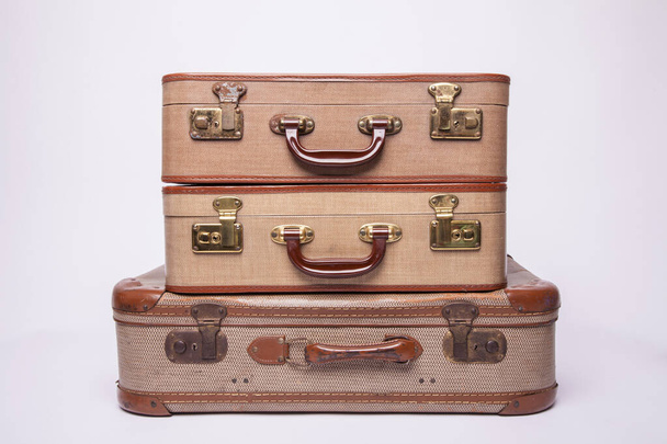 Старые, ретро, чемоданы лежат на столе с белым фоном
 - Фото, изображение
