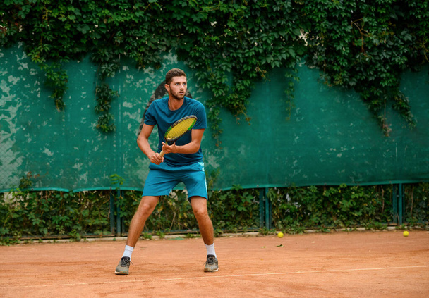 Homem concentrado jogando tênis, segurando uma raquete e assistindo o bal
 - Foto, Imagem