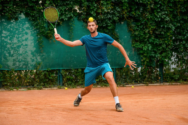 Young player practicing his tennis skills on the court - Photo, Image