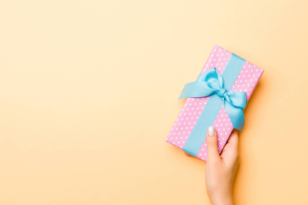 Flat lay of woman hands holding gift wrapped and decorated with  - Photo, Image