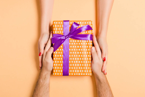 Top view of giving and receiving a gift on colorful background.  - Photo, Image