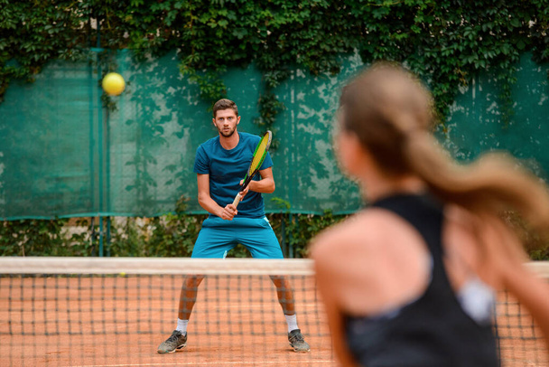 Couple playing tennis at outdoor court and have fun. - Foto, imagen