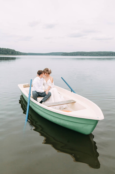  Stylish wedding in European style. Happy couple on a boat on the lake. - Фото, изображение