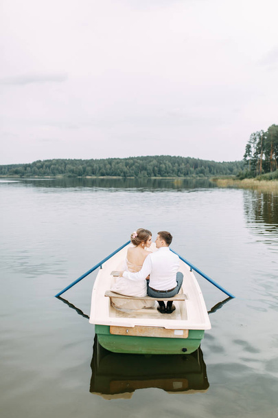  Stylish wedding in European style. Happy couple on a boat on the lake. - Fotoğraf, Görsel