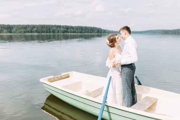  Stylish wedding in European style. Happy couple on a boat on the lake. - Photo, image