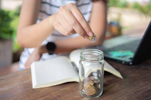 Bizneswoman umieścić monetę w szklanym słoiku Aby zaoszczędzić pieniądze, zapisać mo - Zdjęcie, obraz