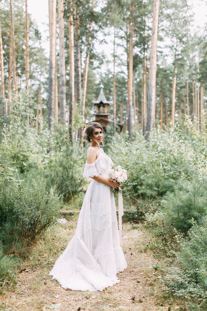 Elegant ceremony in European style. Beautiful bride in white flying dress in the forest.  - Foto, Imagen