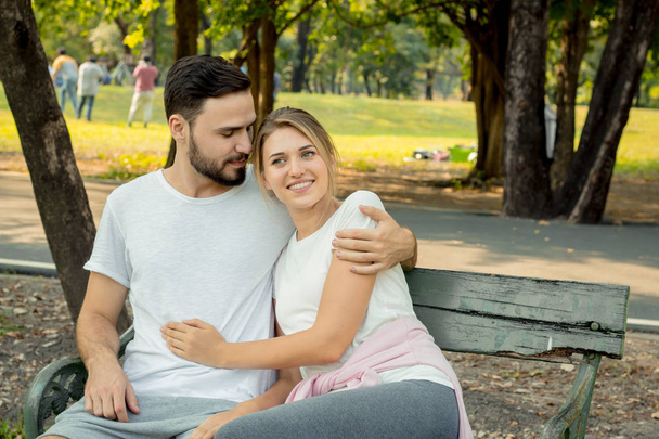 Couples sitting and hugging in the park. - Фото, изображение