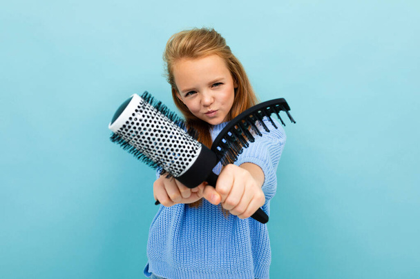 little girl posing with two hairbrushes against blue background  - Photo, Image