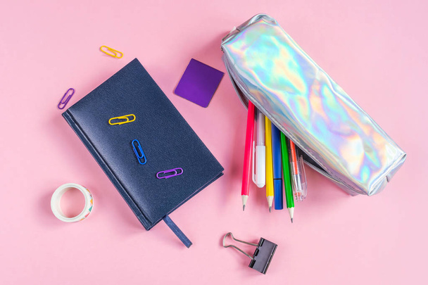 ペンや鉛筆、紙クリップ、ブックマーク、ノートブック、ピンクの背景に他の文房具と鉛筆ケース。テキスト、ミニマリズムのための場所。学校、オフィス、教育の概念. - 写真・画像