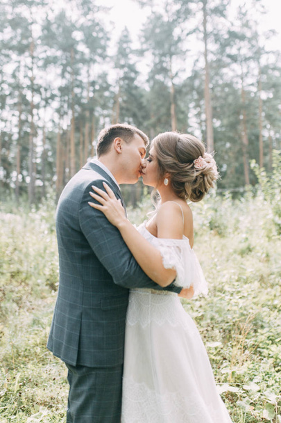 Modern ceremony in European style. Beautiful wedding couple in atmospheric forest with rocks.  - 写真・画像