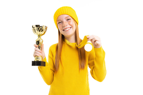 可愛いですティーン女の子で黄色の帽子ポージングとともに賞とともに白の背景   - 写真・画像