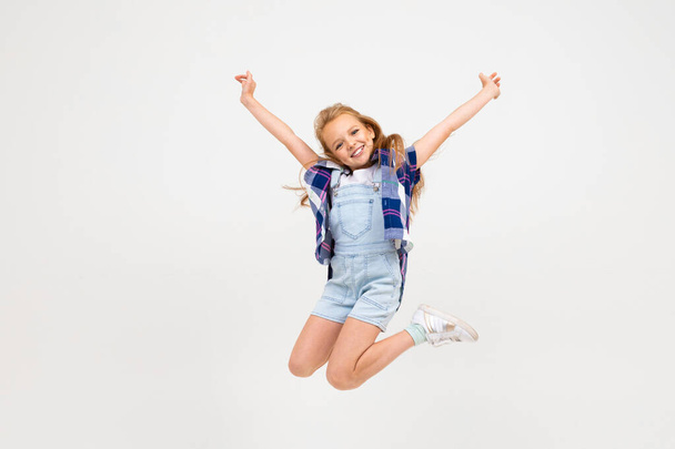 söpö emotionaalinen pieni tyttö poseeraa studiossa harmaata taustaa vasten
 - Valokuva, kuva