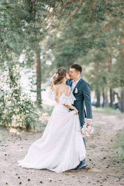 Stylish European wedding at sunset. Happy couple in the forest in nature.  - Foto, afbeelding
