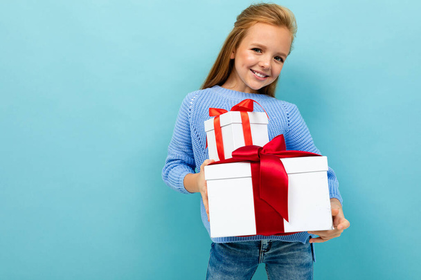 petite fille posant avec deux cadeaux sur fond bleu
  - Photo, image