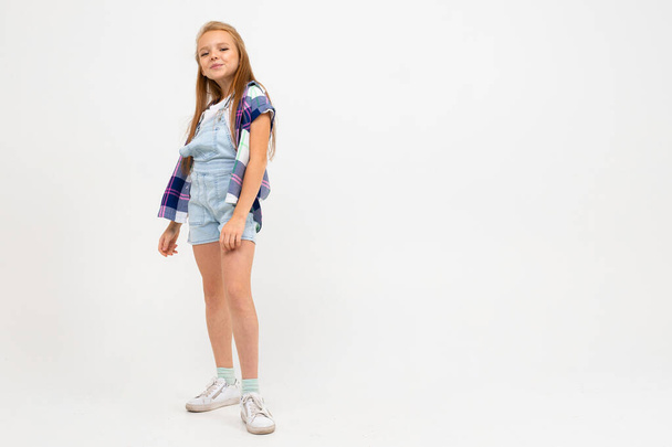 söpö emotionaalinen pieni tyttö poseeraa studiossa harmaata taustaa vasten
 - Valokuva, kuva