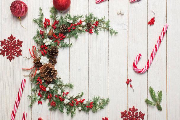 Christmas wreath on white wooden backdrop - Fotó, kép
