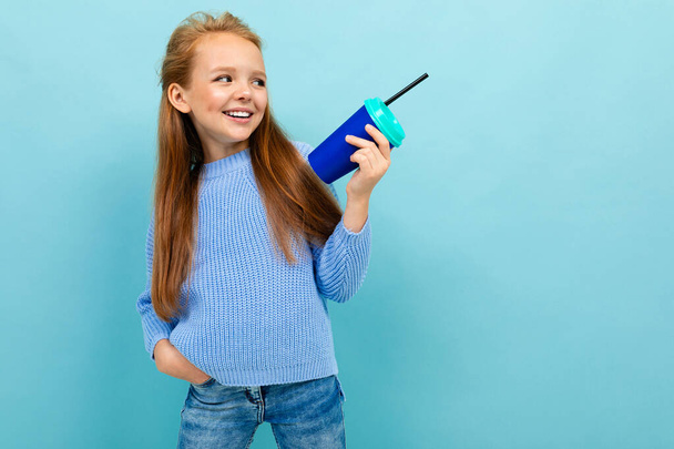 aranyos kislány pózol papír üveg ellen kék háttér  - Fotó, kép