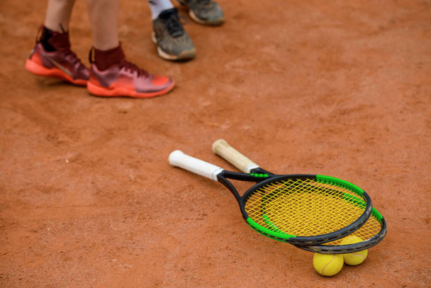 Tennis rackets and balls on the ground of an outdoor court. - Foto, afbeelding
