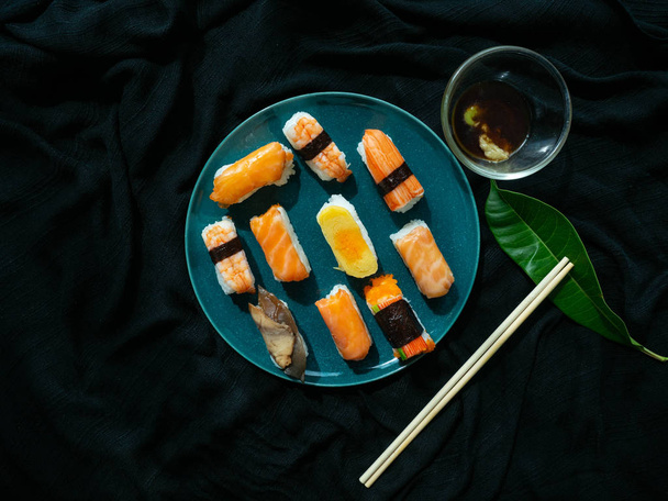 Sushi set on dish with Shrimp Sweet egg Salmon Crab stick Saba,Japanese food is good health,Color black background,Black cloth foundation - Photo, Image