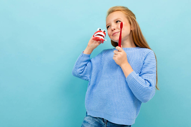 little girl posing with toothbrush against blue background  - Foto, Imagem